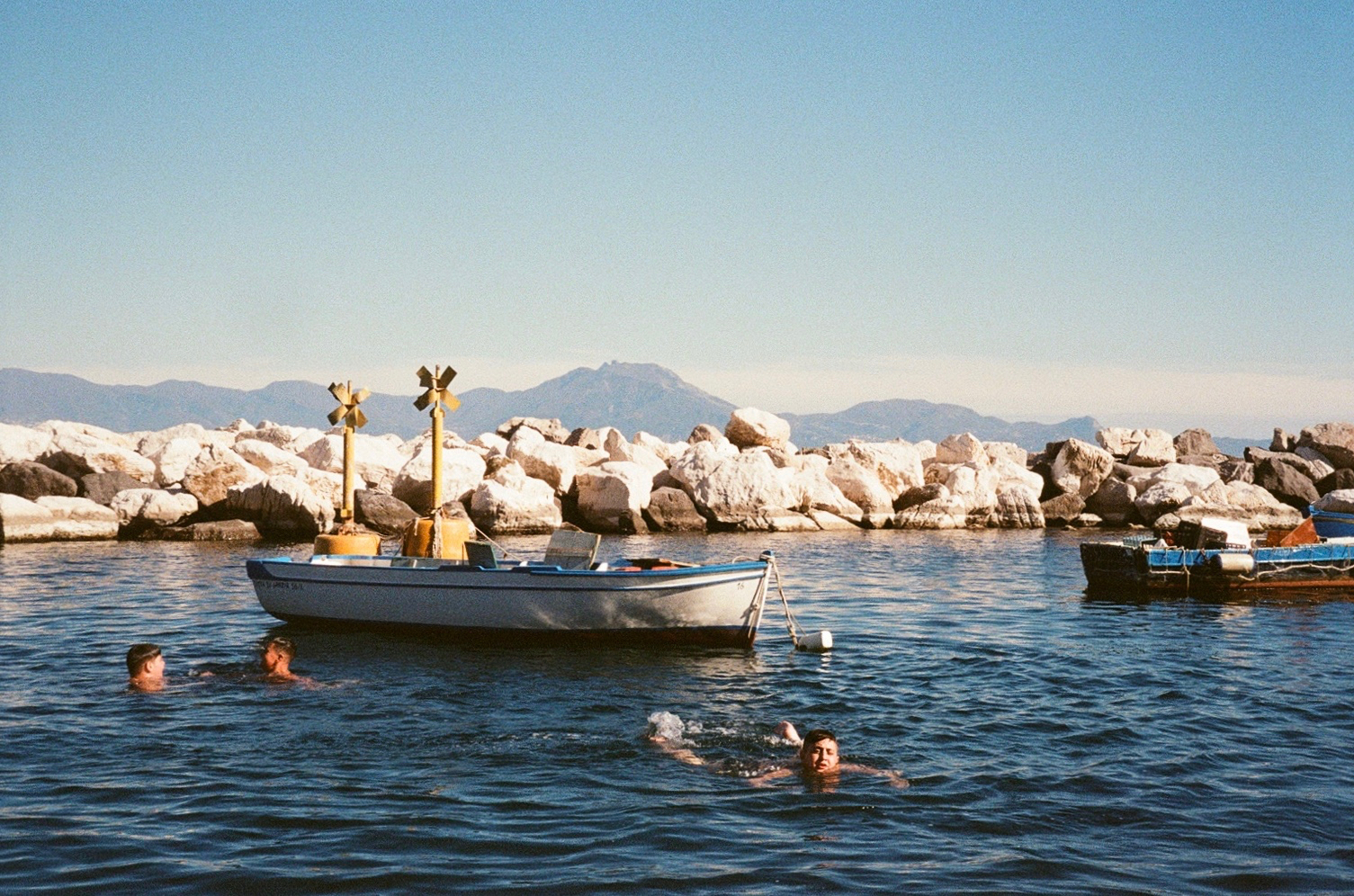 Children swimming in the Gulf of Naples at Borgo Marinari, Campania, Italy, April 2019.